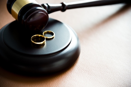 Two gold wedding bands on a gavel